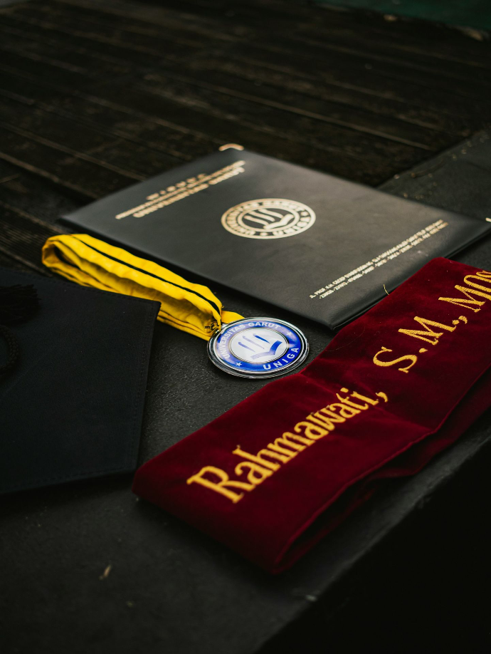 Graduation diploma, medal, and sash displayed.